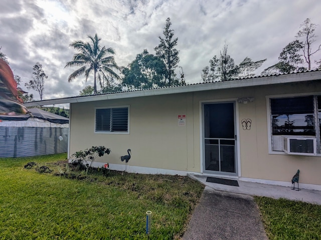 exterior space featuring cooling unit and a lawn