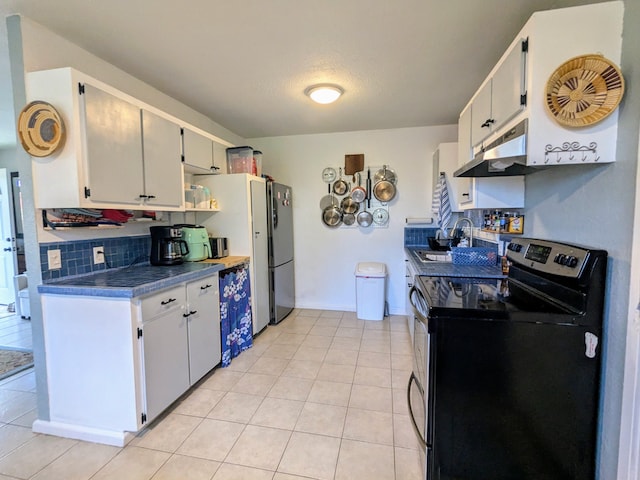 kitchen featuring light tile patterned flooring, white cabinetry, appliances with stainless steel finishes, and sink