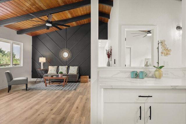 living room with vaulted ceiling with beams, wooden ceiling, ceiling fan, and light hardwood / wood-style flooring