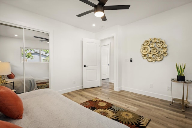 bedroom featuring ceiling fan, wood-type flooring, and a closet