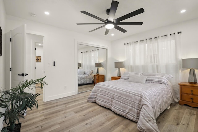 bedroom with ceiling fan, light wood-type flooring, and a closet