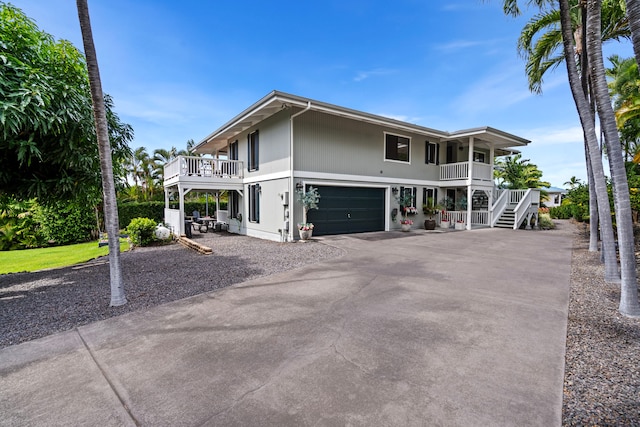 raised beach house featuring a porch and a garage