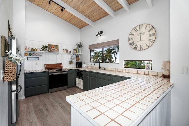 kitchen with sink, green cabinets, tile countertops, and appliances with stainless steel finishes