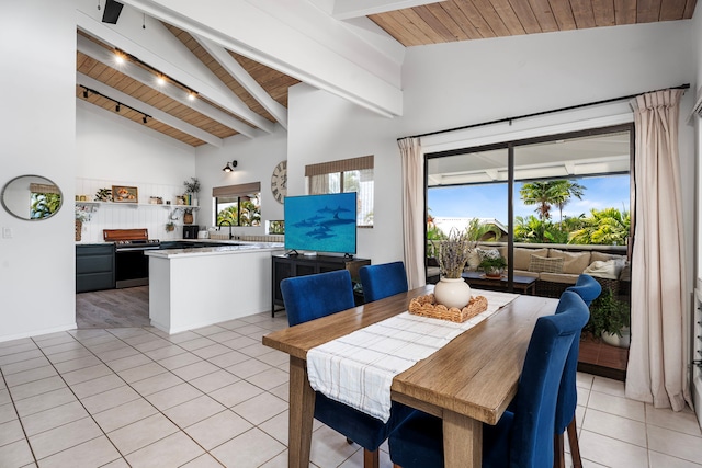 dining room featuring beamed ceiling, sink, light tile patterned floors, and wood ceiling