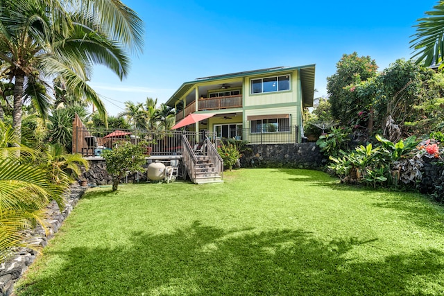 back of property featuring a balcony, a yard, and ceiling fan