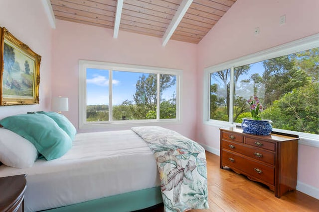 bedroom with light hardwood / wood-style flooring, wooden ceiling, and lofted ceiling with beams