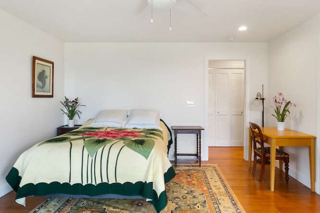 bedroom featuring hardwood / wood-style floors, a closet, and ceiling fan