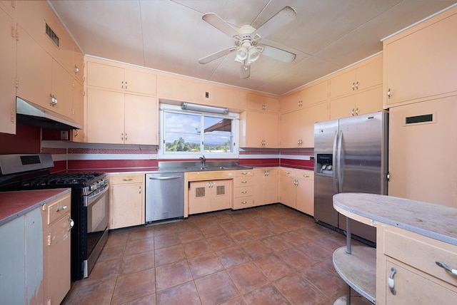 kitchen with cream cabinets, appliances with stainless steel finishes, sink, and ceiling fan