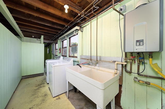 clothes washing area with sink, washer and clothes dryer, and tankless water heater