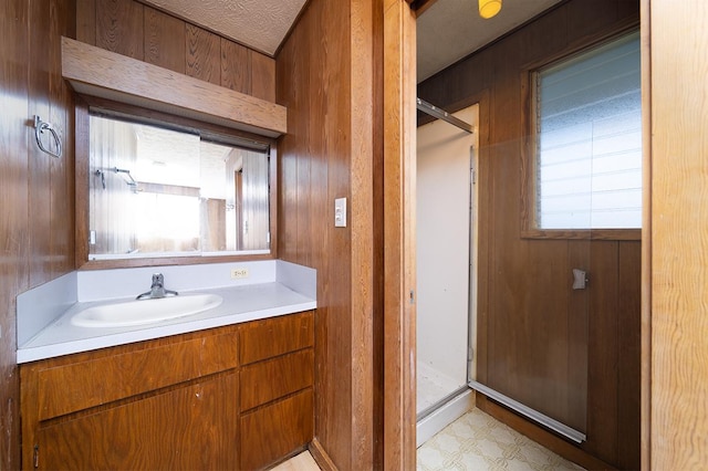 bathroom featuring vanity, wooden walls, and a shower