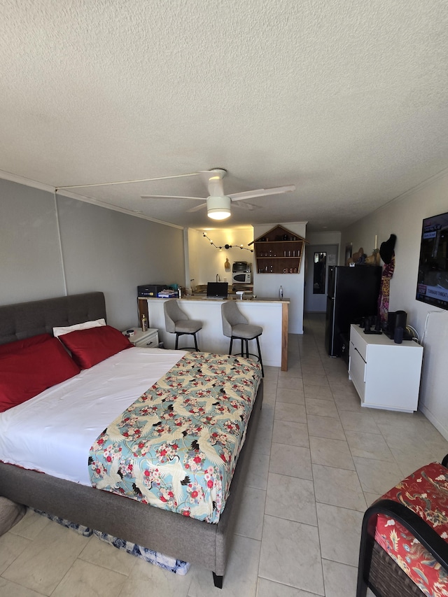 bedroom with ceiling fan, a textured ceiling, light tile patterned floors, and black fridge