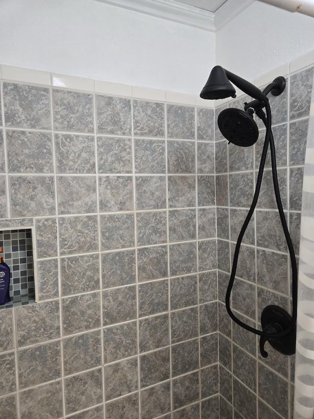 interior details featuring tiled shower and crown molding