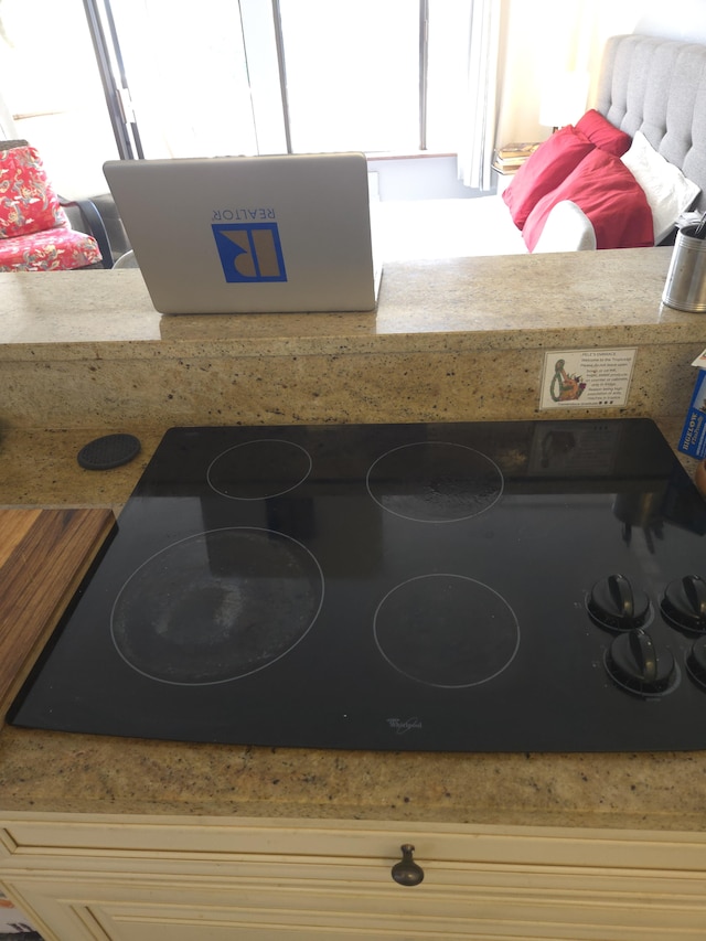 interior details with light stone countertops and black cooktop