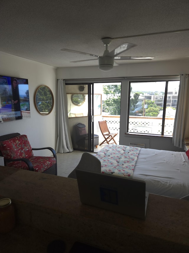 bedroom featuring ceiling fan, tile patterned floors, and a textured ceiling