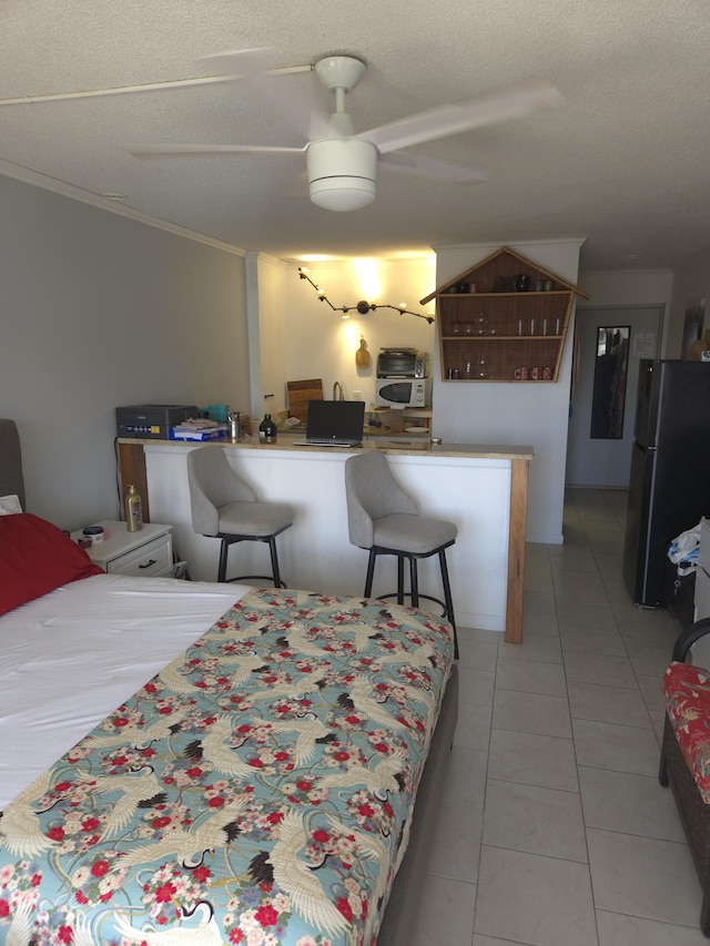 tiled bedroom featuring ceiling fan, ornamental molding, black fridge, and a textured ceiling