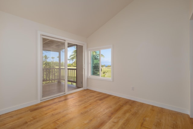 empty room with light hardwood / wood-style flooring and high vaulted ceiling