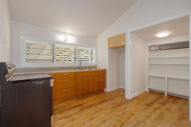 kitchen with sink, light hardwood / wood-style floors, range with electric stovetop, and lofted ceiling