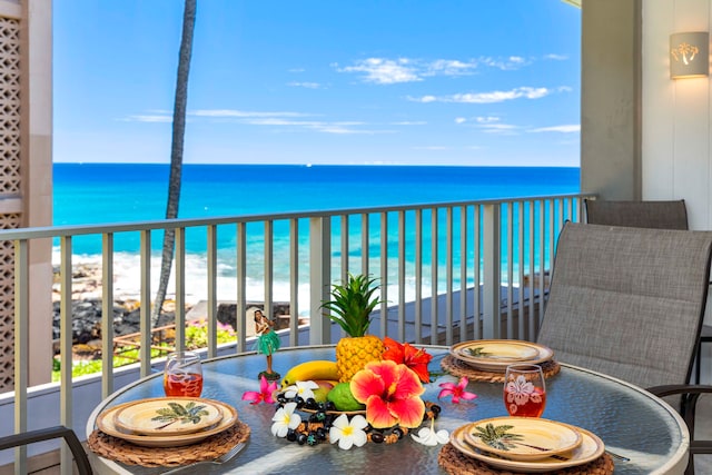 balcony with a water view and a view of the beach