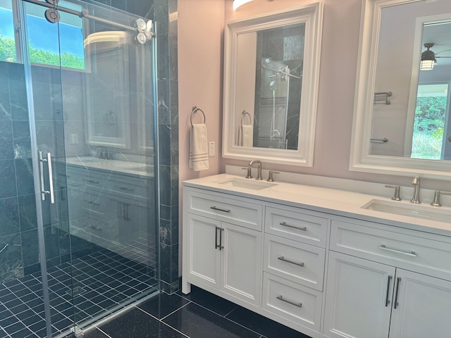 bathroom with a shower with door, vanity, and tile patterned floors