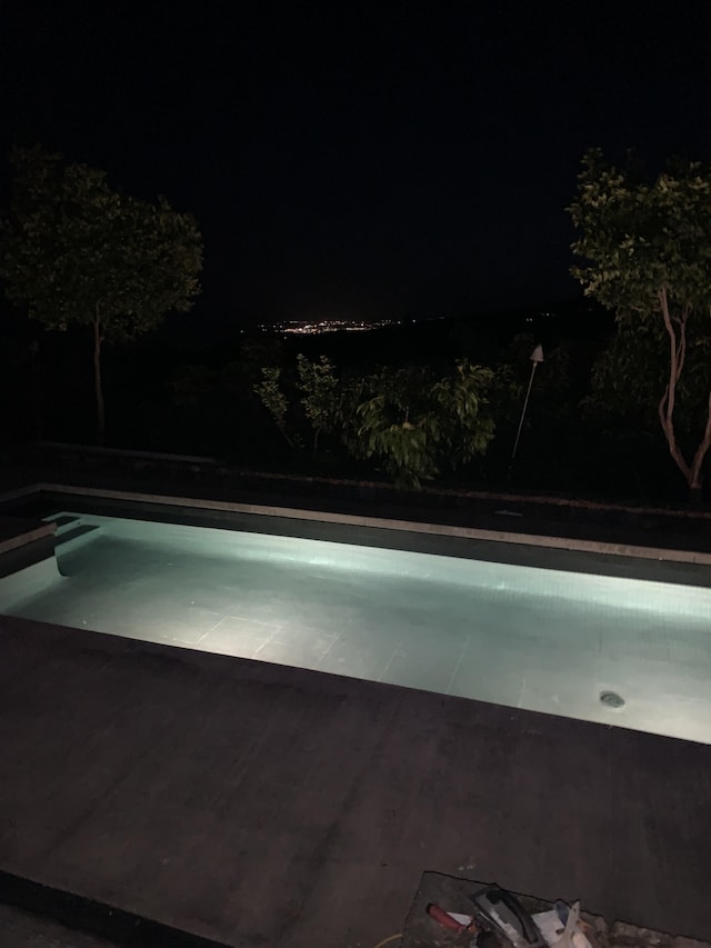 view of pool at twilight