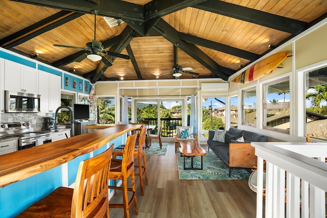 interior space with lofted ceiling with beams, ceiling fan, wooden ceiling, and a sink