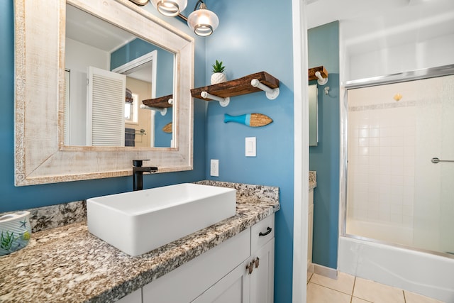 full bath featuring shower / bath combination with glass door, tile patterned floors, and vanity