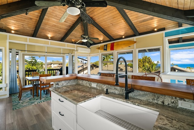 kitchen with dark wood-style flooring, white cabinetry, a sink, dark stone counters, and wooden ceiling