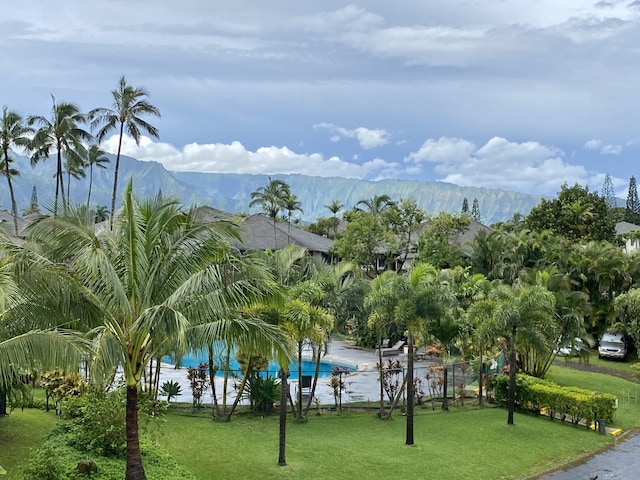 view of home's community featuring a mountain view and a lawn