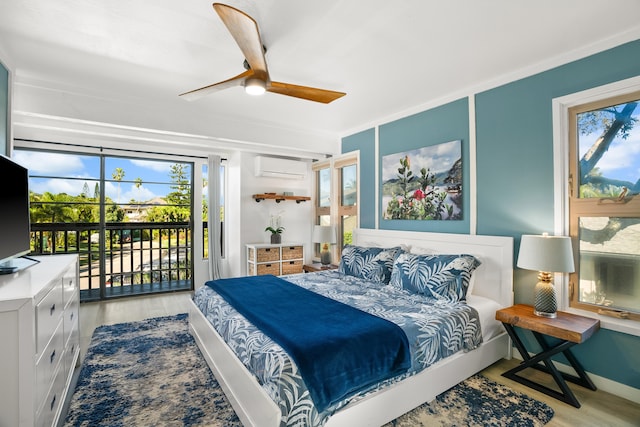 bedroom featuring access to outside, a wall unit AC, ceiling fan, and light wood-style flooring