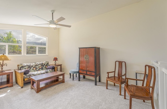 living area with ceiling fan and light carpet