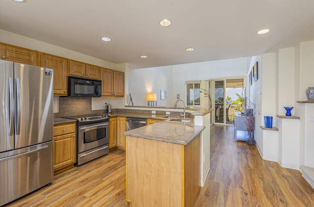 kitchen featuring sink, backsplash, light hardwood / wood-style flooring, and stainless steel appliances