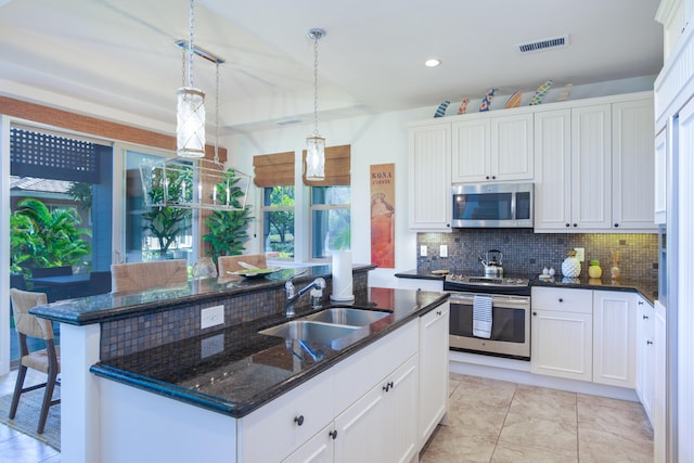 kitchen featuring sink, hanging light fixtures, white cabinets, stainless steel appliances, and backsplash