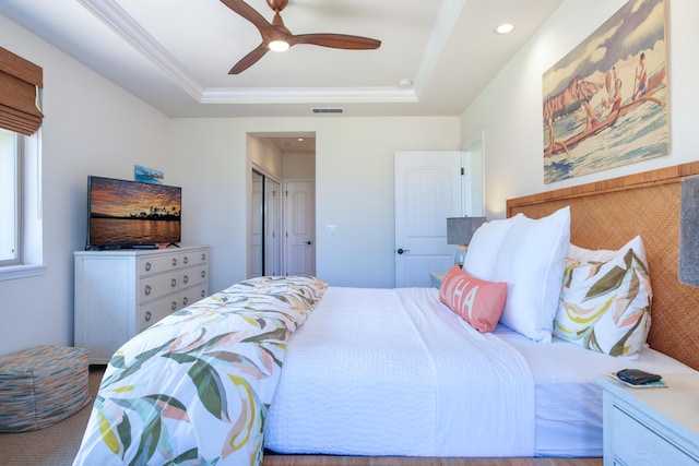 bedroom with crown molding, a raised ceiling, and ceiling fan