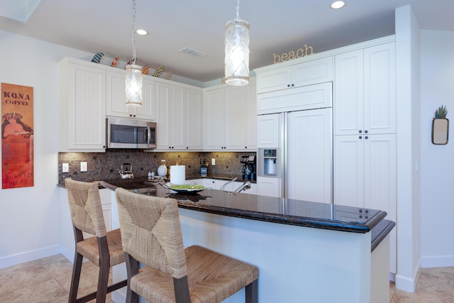 kitchen with white cabinetry, a kitchen breakfast bar, kitchen peninsula, and hanging light fixtures