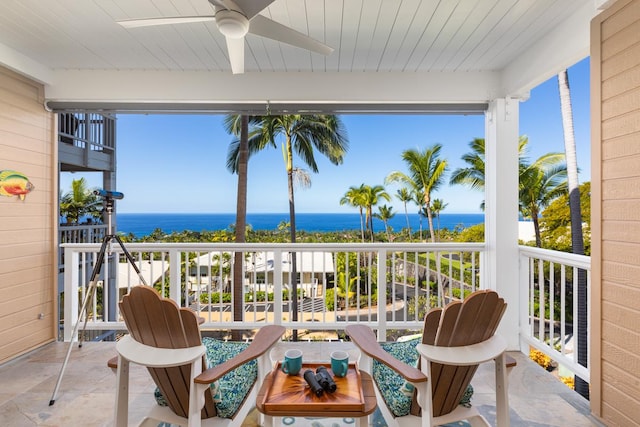 balcony with a water view and ceiling fan