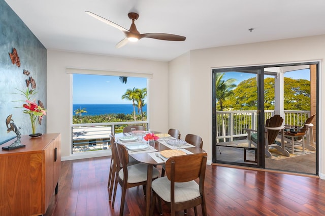 dining room featuring a water view, ceiling fan, and dark hardwood / wood-style flooring