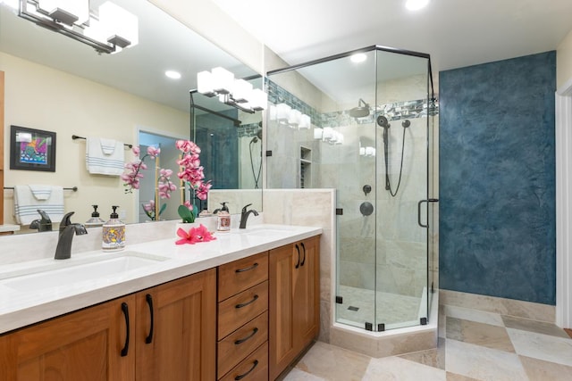 bathroom featuring a shower with door and vanity