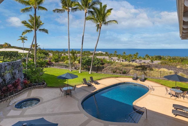 view of pool featuring a yard, a patio area, an in ground hot tub, and a water view