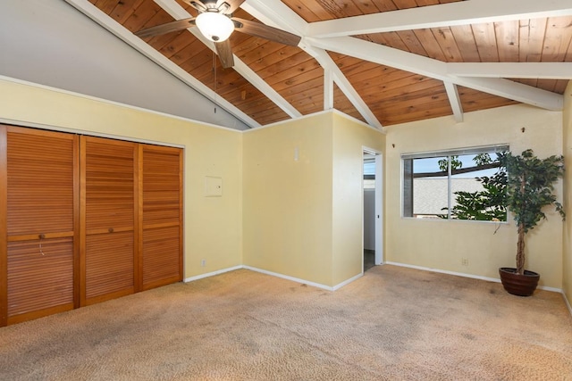 unfurnished bedroom with carpet, vaulted ceiling with beams, and a closet