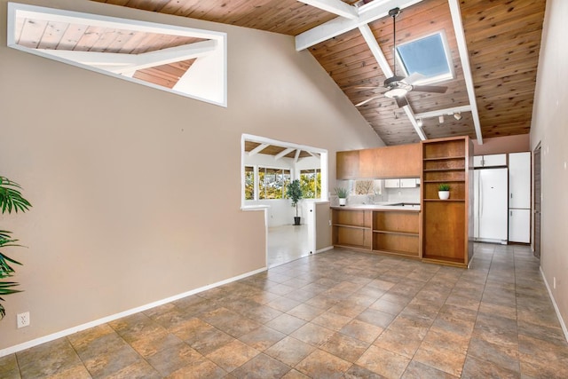 kitchen featuring wood ceiling, a skylight, white fridge, beamed ceiling, and ceiling fan