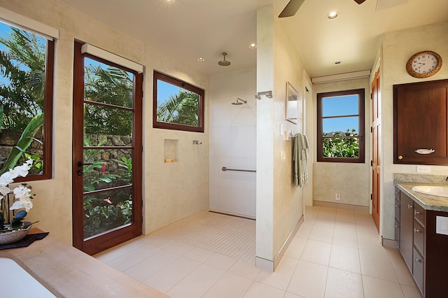 bathroom featuring vanity, tile patterned flooring, and tiled shower