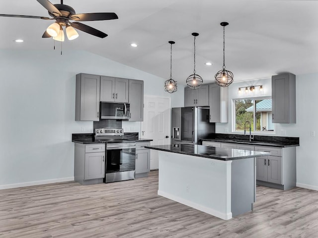 kitchen featuring appliances with stainless steel finishes, sink, gray cabinets, a kitchen island, and lofted ceiling