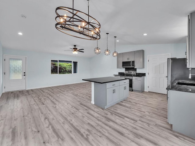 kitchen featuring pendant lighting, ceiling fan, light wood-type flooring, gray cabinets, and stainless steel appliances