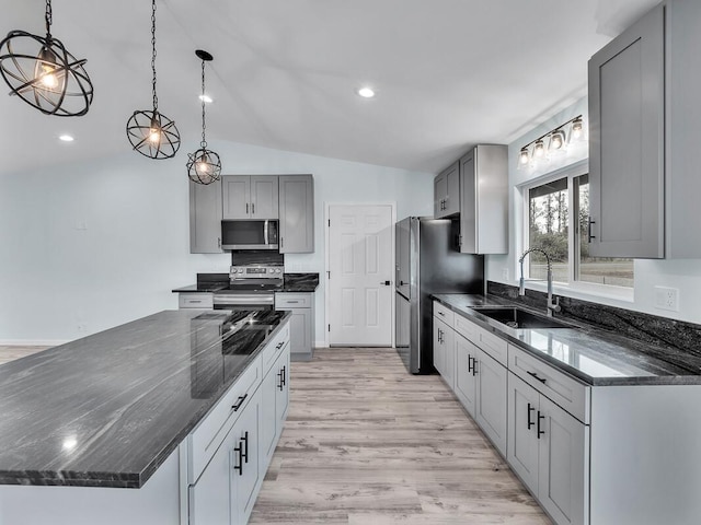 kitchen featuring sink, gray cabinets, vaulted ceiling, and appliances with stainless steel finishes