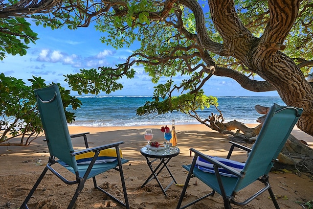 view of patio with a water view and a view of the beach