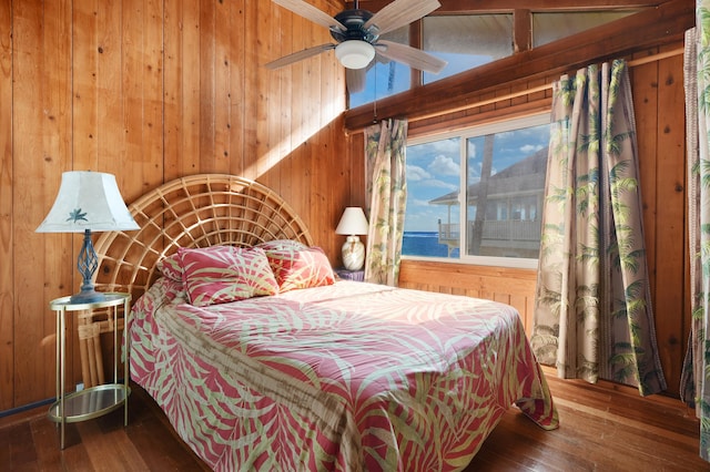 bedroom with wood-type flooring and wooden walls