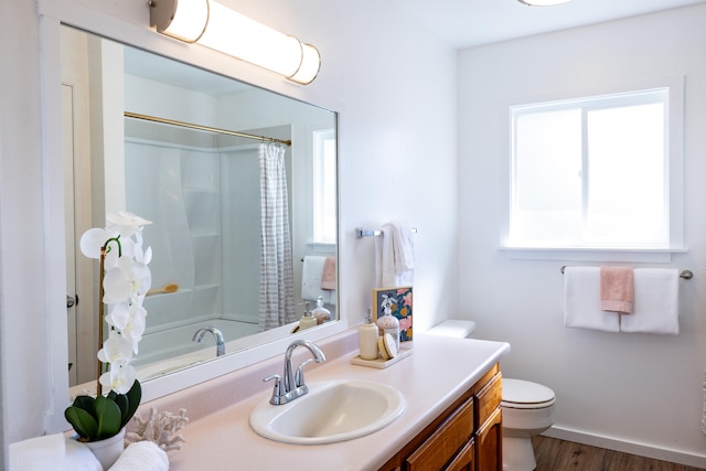 full bathroom with hardwood / wood-style flooring, vanity, shower / tub combo, and toilet