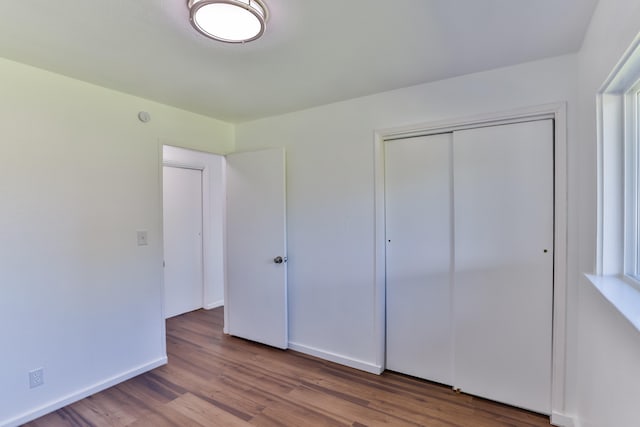 unfurnished bedroom featuring hardwood / wood-style floors and a closet