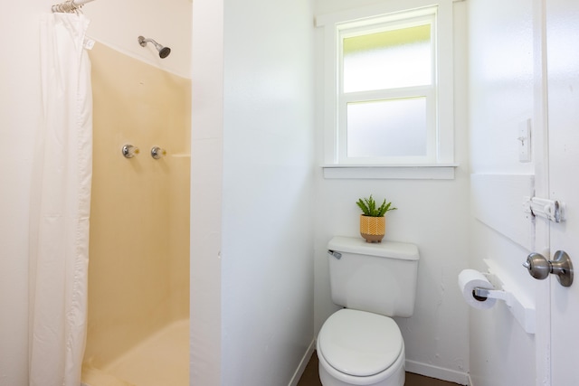 bathroom with a shower with curtain and toilet