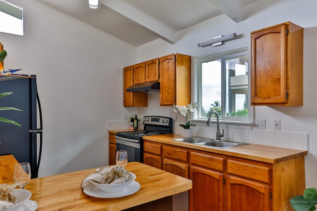 kitchen with sink, wooden counters, black fridge, beam ceiling, and electric stove